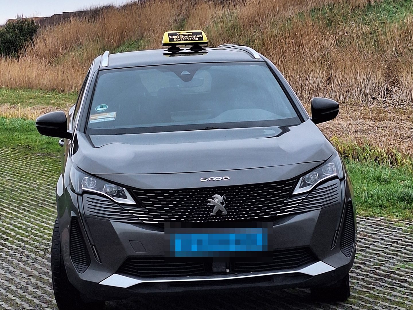 Grijze Peugeot 5008 met taxibord, de personenauto van Taxi Bouwman